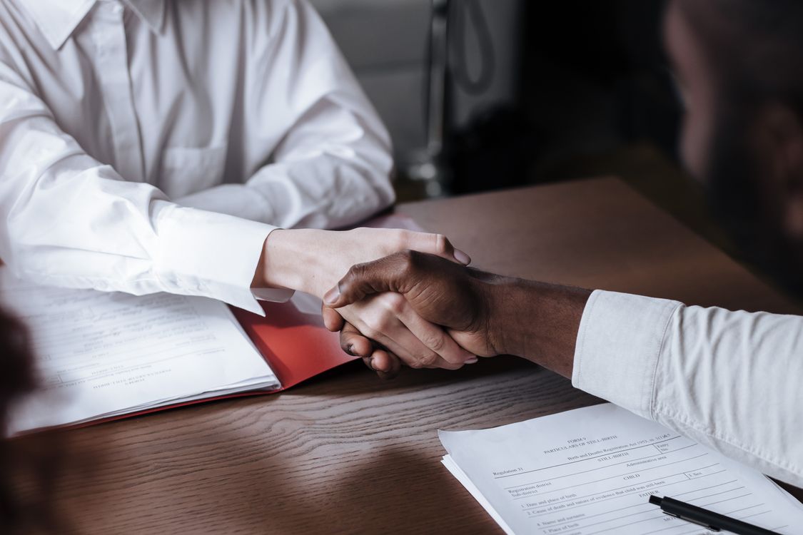 Business partners shaking hands over documents